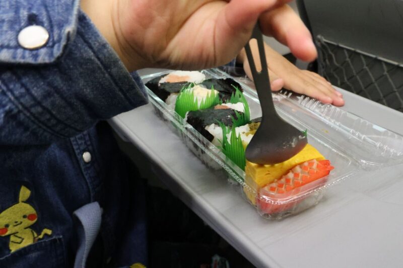 おにぎりが大好きで、特急の車内でおにぎり弁当を食べる子ども